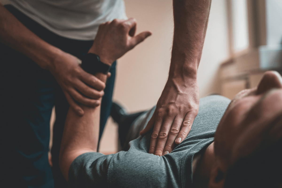 Ostéopathe réalisant une manipulation sur un patient allongé dans son cabinet libéral